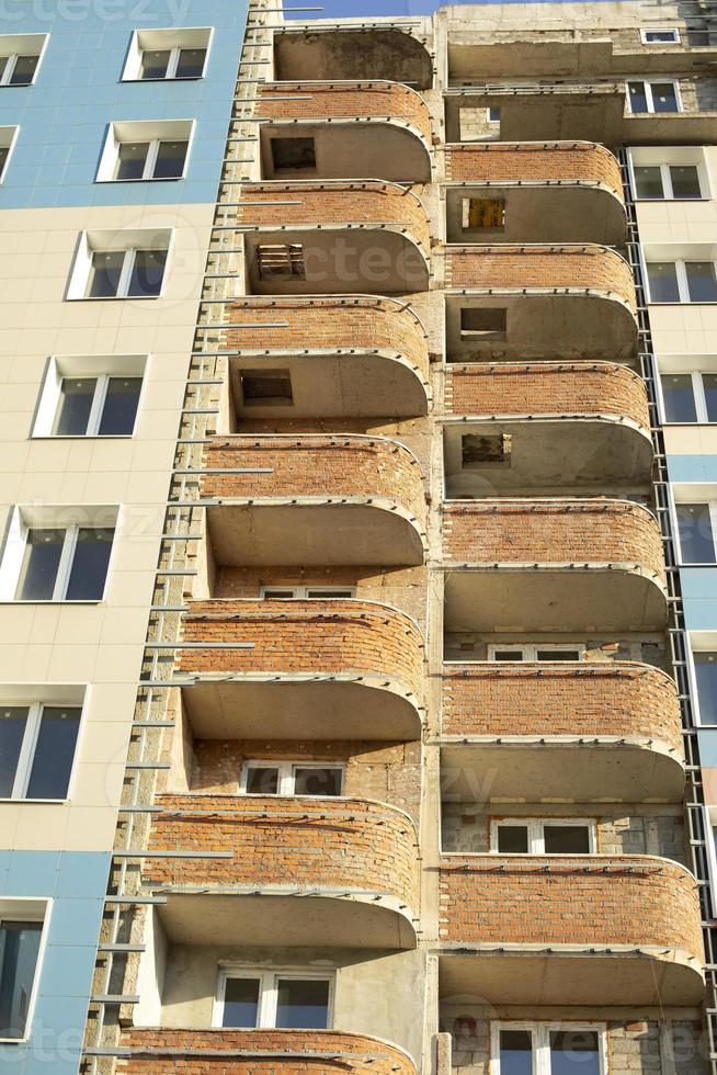 Balconies of building. House cladding. Construction of new residential complex. photo