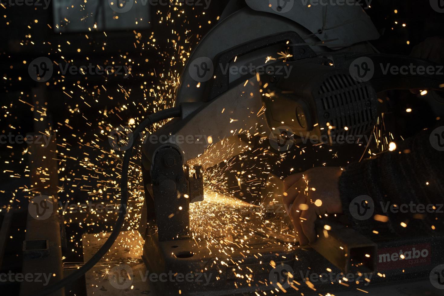 Sparks in dark. Cutting steel. Industrial equipment. photo