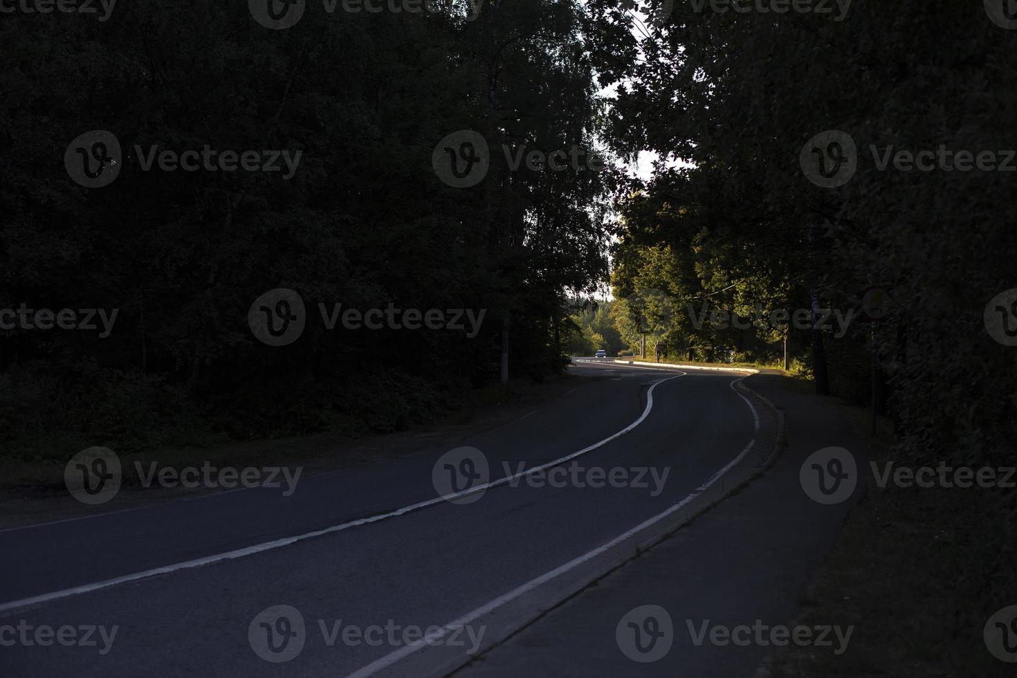 Light at end of road. Highway in countryside. Road with white stripe. Track outside city. photo