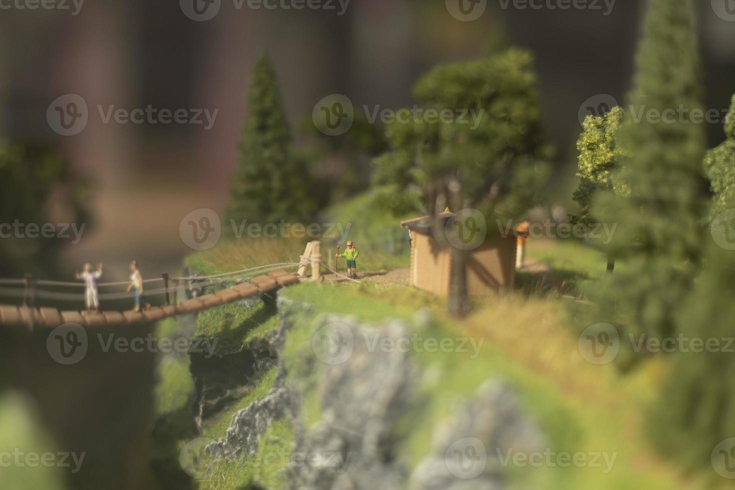 Toy model of park. People on bridge. Tourists in mountains in summer. photo