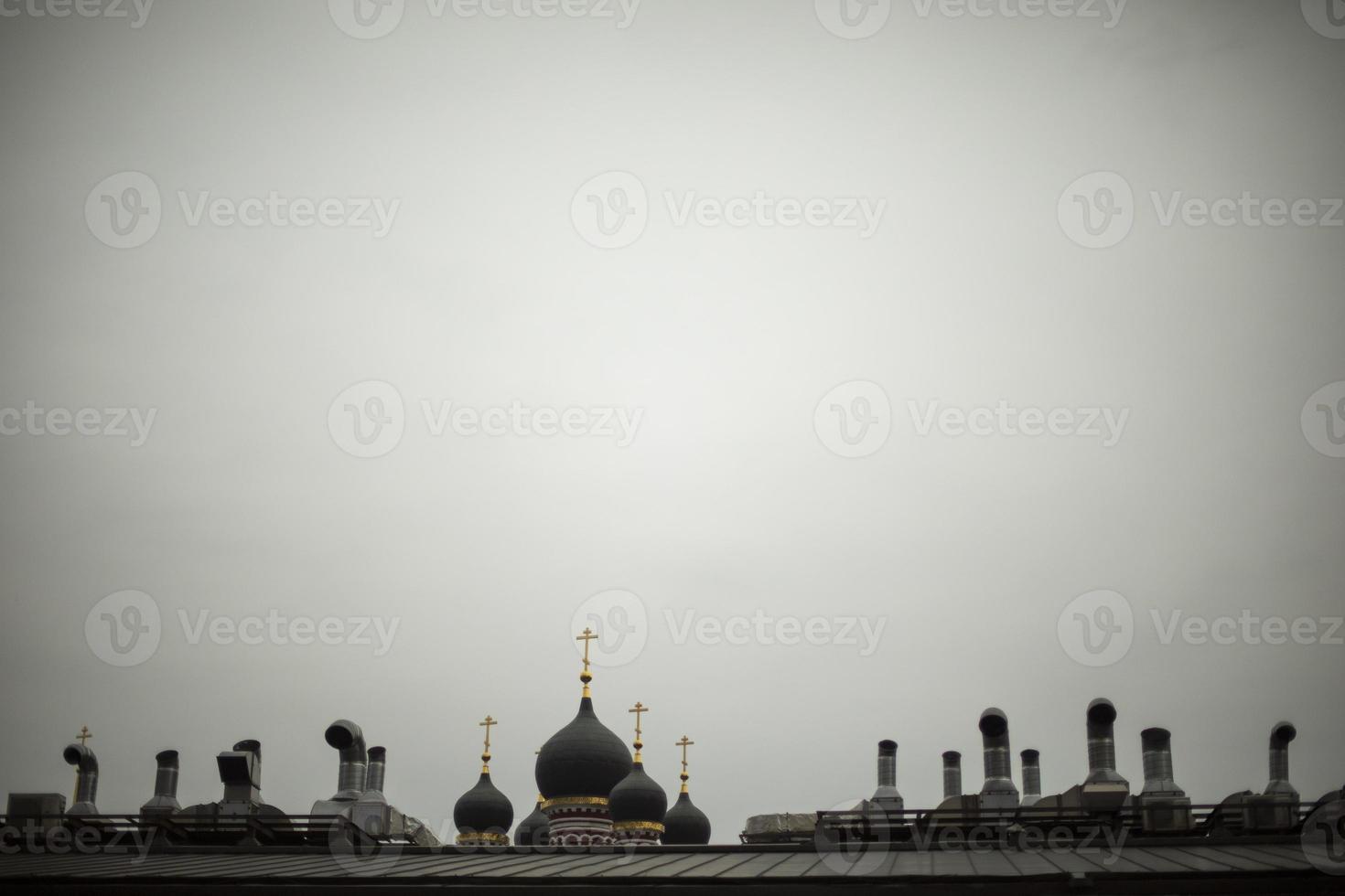 Roof of house and Orthodox cross. View of roof in city. Russian city in detail. Pipes on building. photo