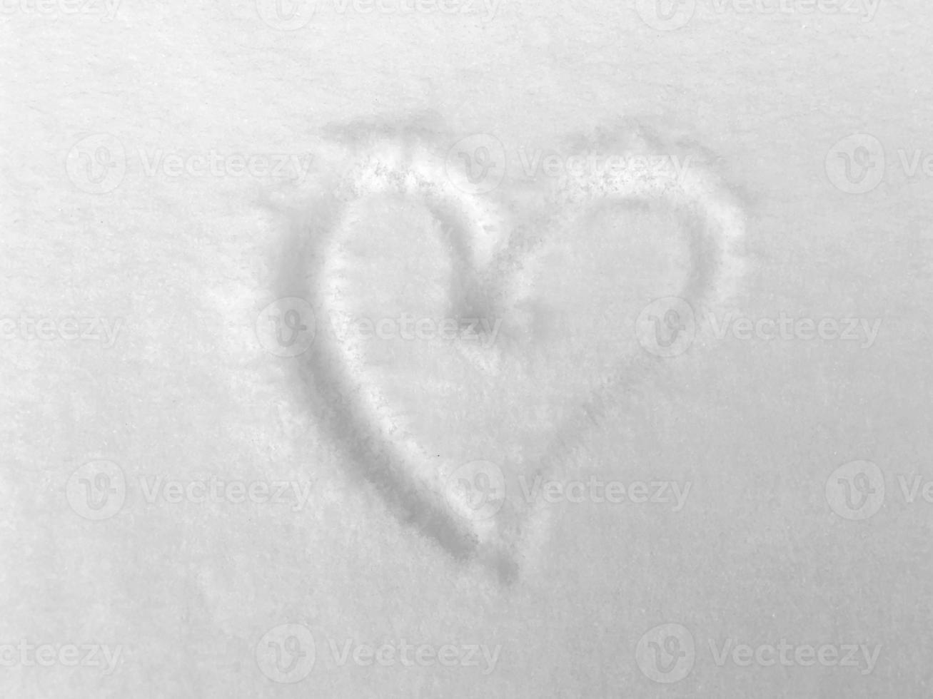 la textura de la nieve y un corazón dibujado en la nieve. foto