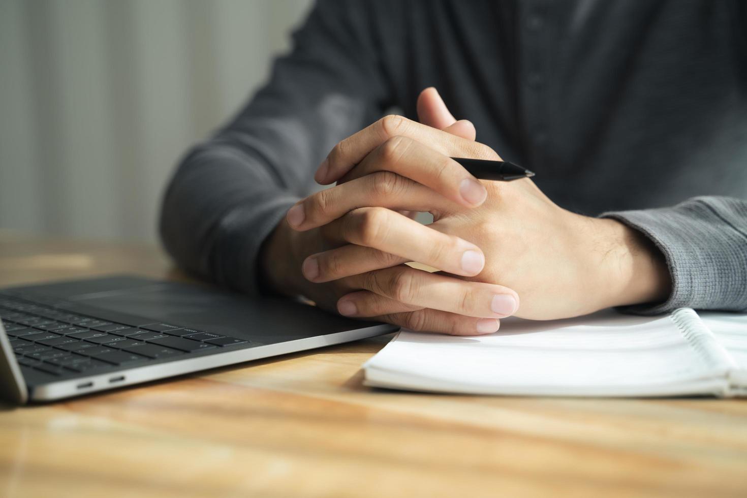 cierre de las manos del hombre apretadas juntas en la mesa, hombre de negocios preparándose para una entrevista de trabajo, concentrándose antes de negociaciones importantes, pensando o tomando decisiones, concepto de negocio foto