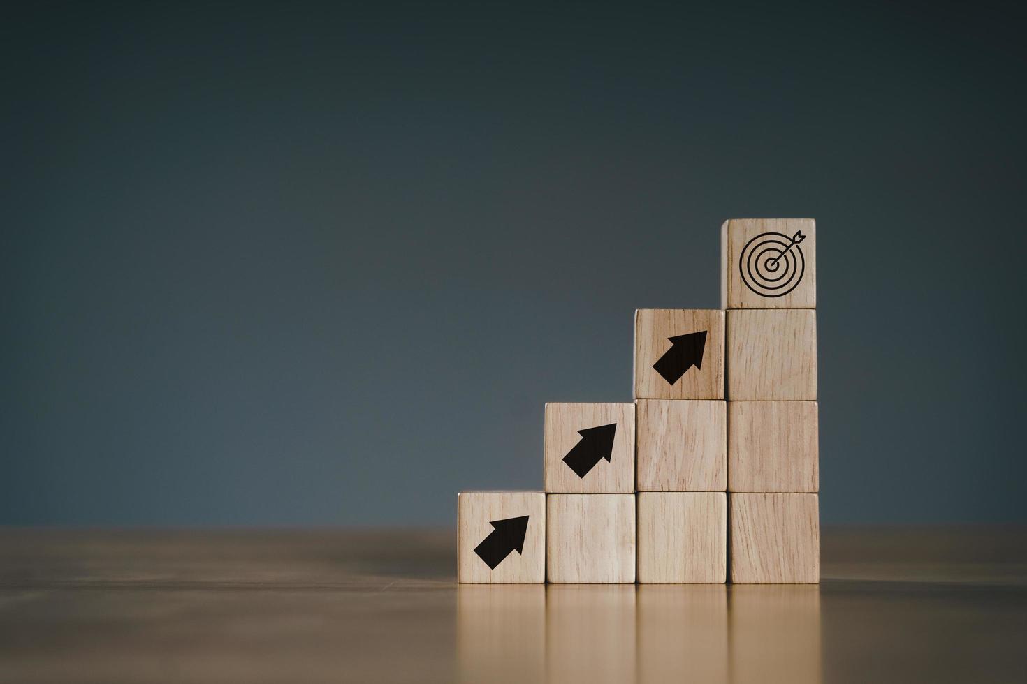 Pile of wooden cube block stack as stair step on wood table. Success, climbing to the top, Progression, business growth concept. photo