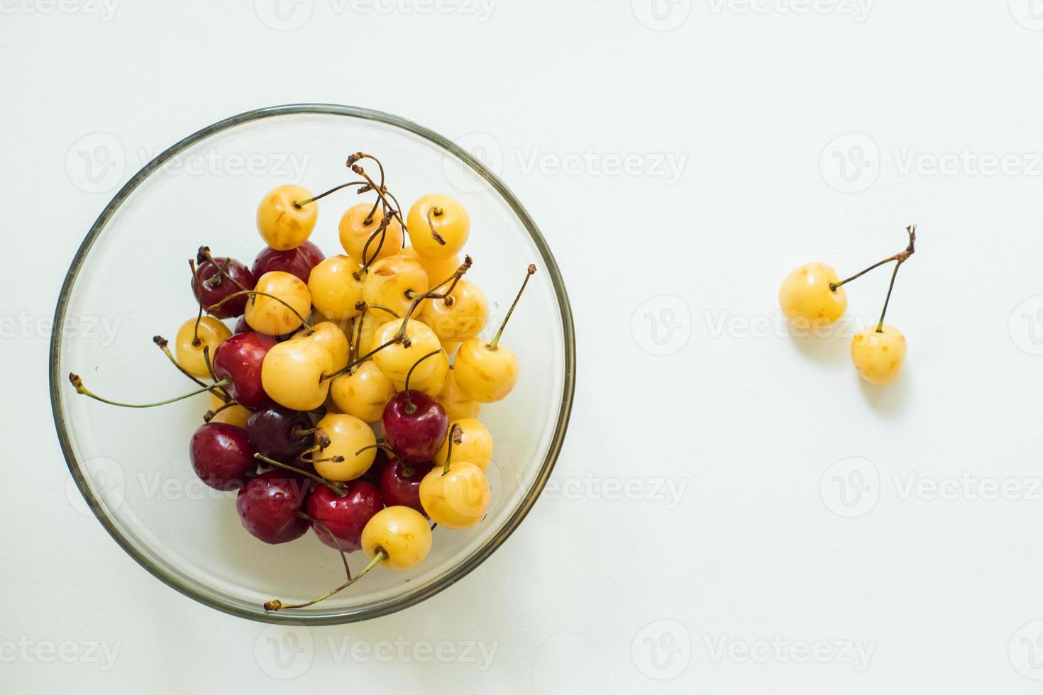 red and yellow cherries in a bowl on a white background photo