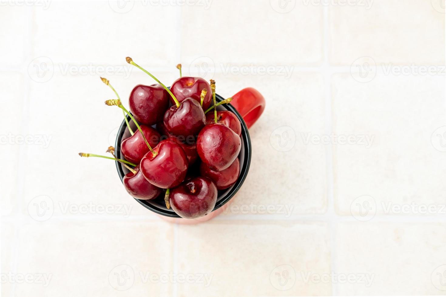 sweet cherry in a red glass on a white background top view, copy space photo