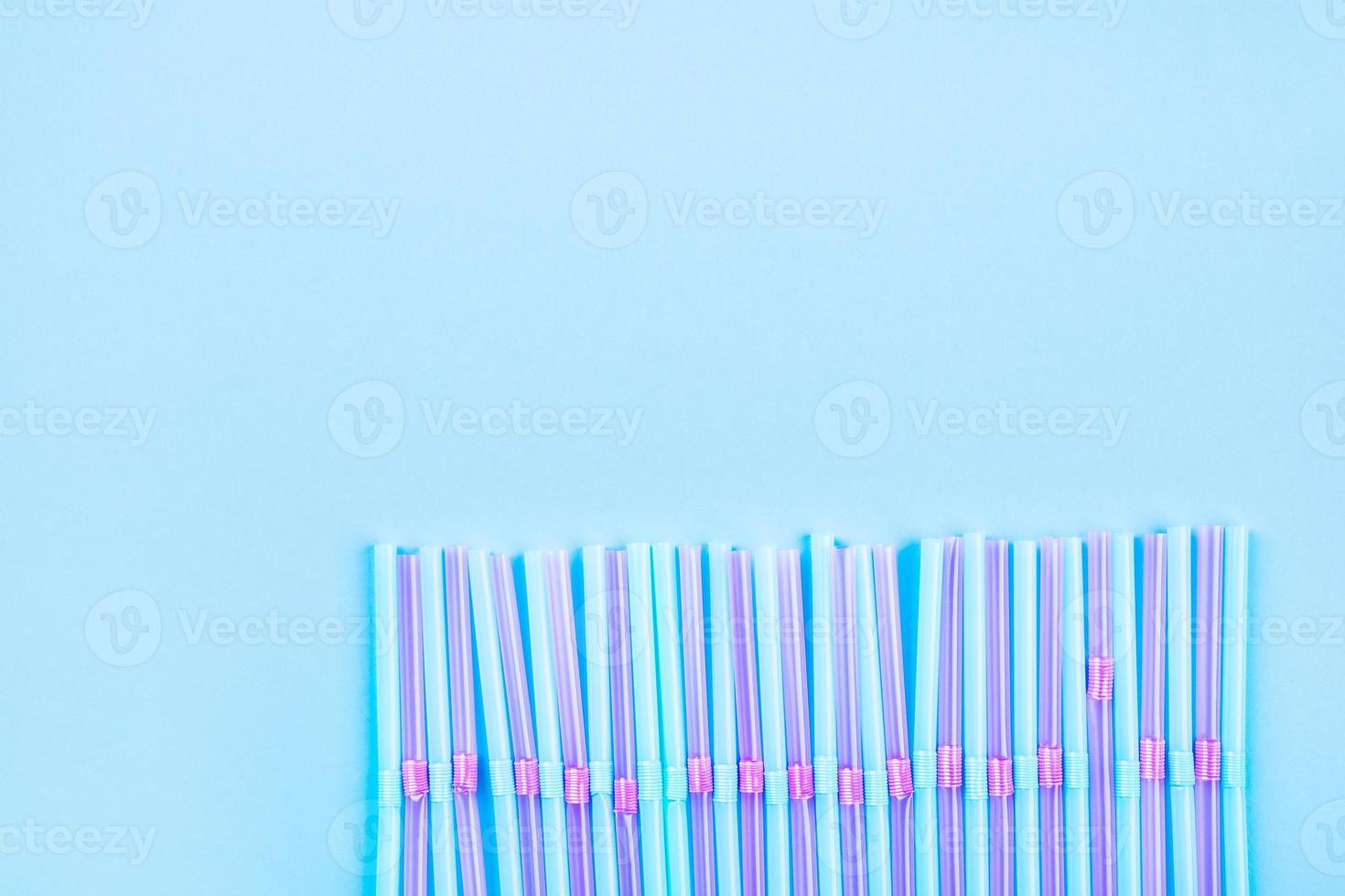 Blue and pink cocktail straws on a color background. photo