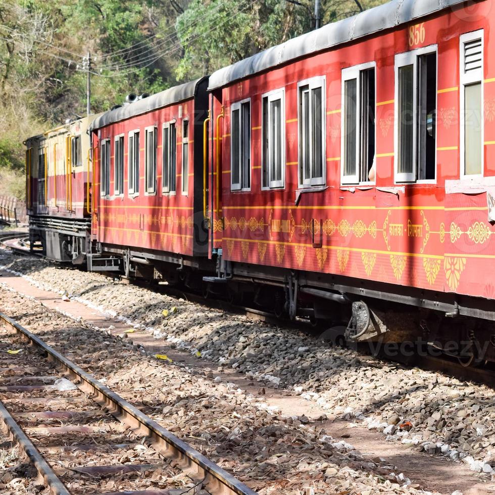 Toy Train moving on mountain slopes, beautiful view, one side mountain, one side valley moving on railway to the hill, among green natural forest. Toy train from Kalka to Shimla in India, Indian Train photo