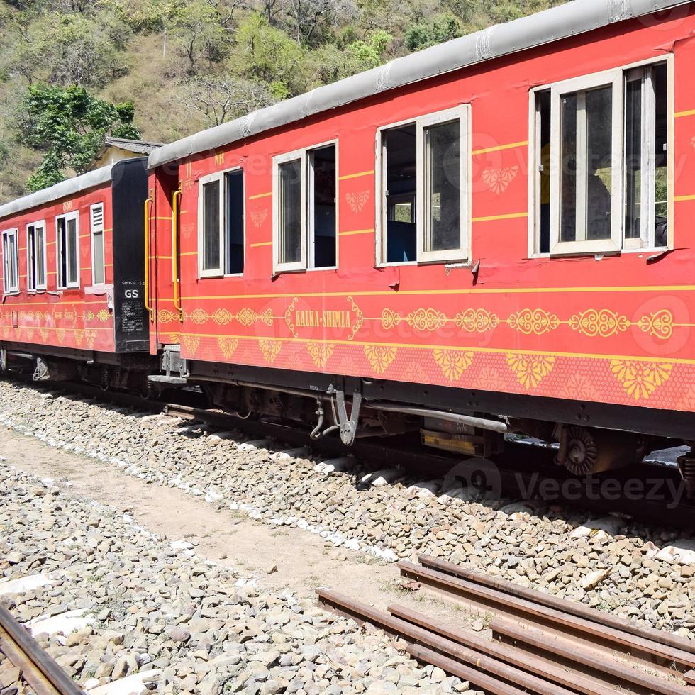 Toy Train moving on mountain slopes, beautiful view, one side mountain, one side valley moving on railway to the hill, among green natural forest. Toy train from Kalka to Shimla in India, Indian Train photo