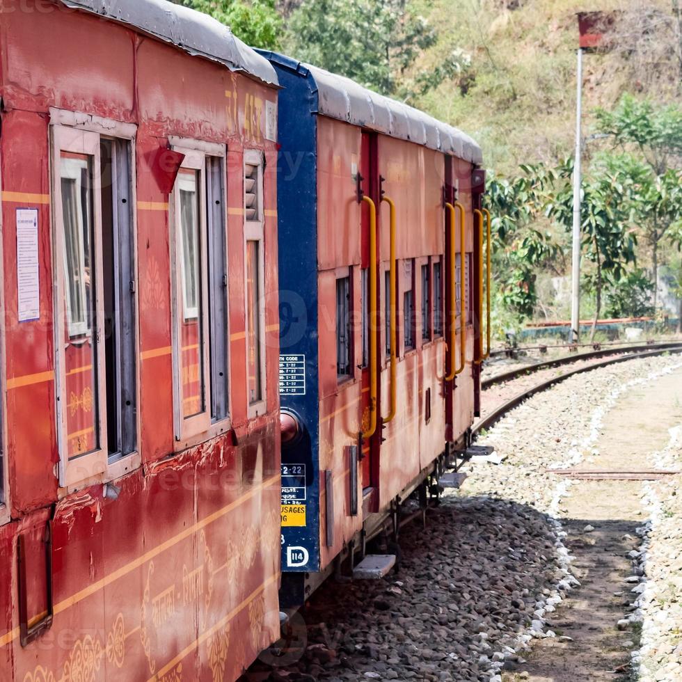 Toy Train moving on mountain slopes, beautiful view, one side mountain, one side valley moving on railway to the hill, among green natural forest. Toy train from Kalka to Shimla in India, Indian Train photo