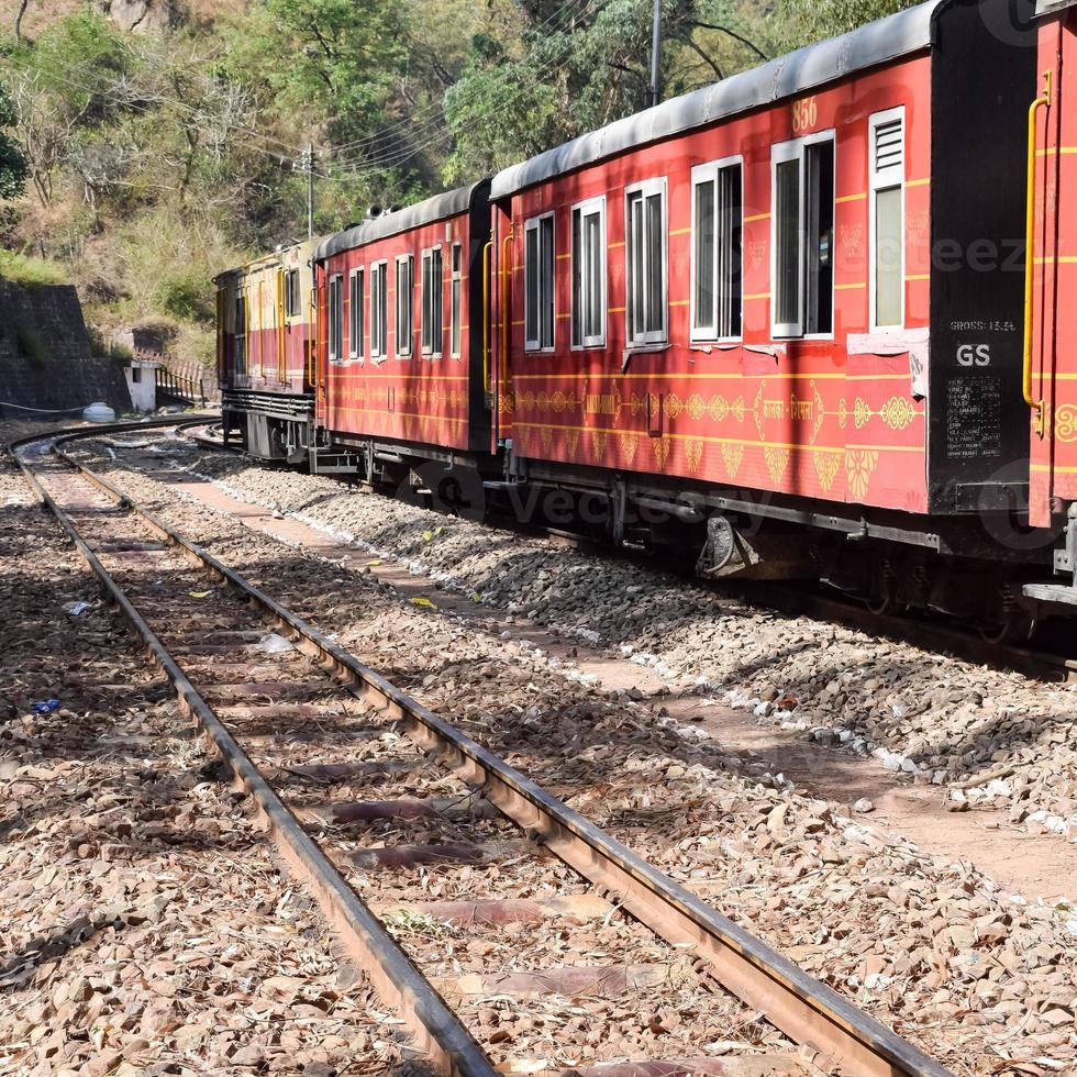 Toy Train moving on mountain slopes, beautiful view, one side mountain, one side valley moving on railway to the hill, among green natural forest. Toy train from Kalka to Shimla in India, Indian Train photo