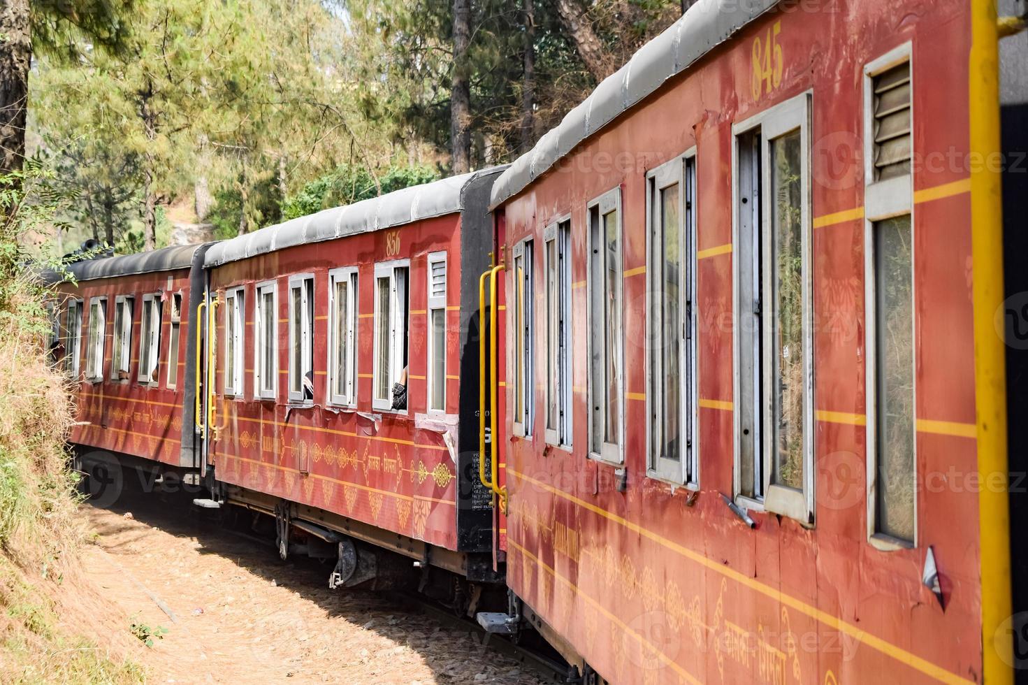 Toy Train moving on mountain slopes, beautiful view, one side mountain, one side valley moving on railway to the hill, among green natural forest. Toy train from Kalka to Shimla in India, Indian Train photo