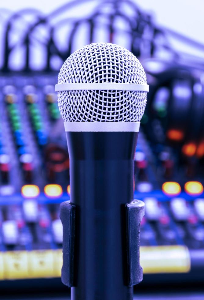 The microphone on tripod in the center of the image with mixer background in sound control room. photo