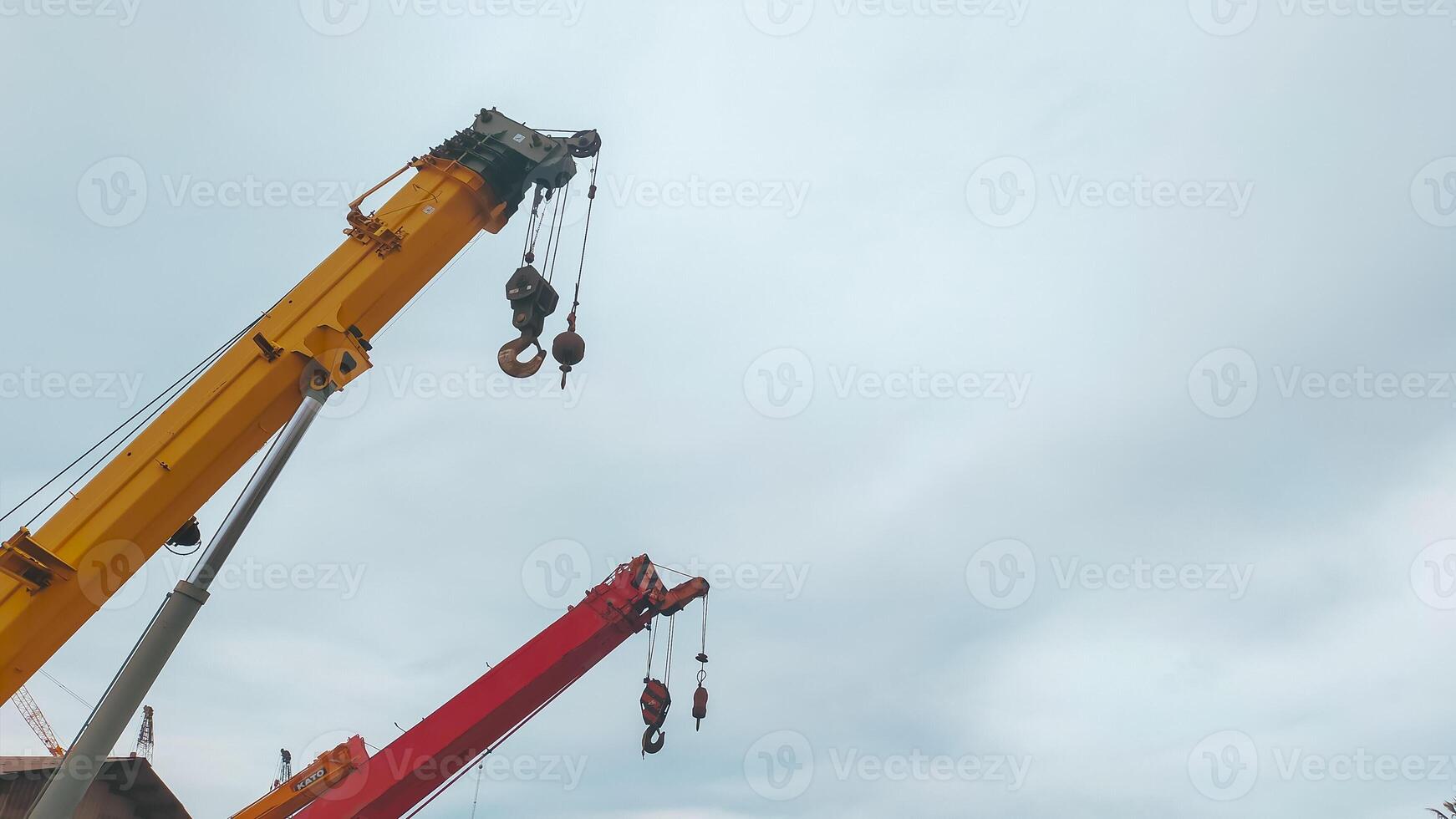 hermosa pluma superior roja y amarilla de grúa móvil telescópica con cielo despejado con nubes. foto