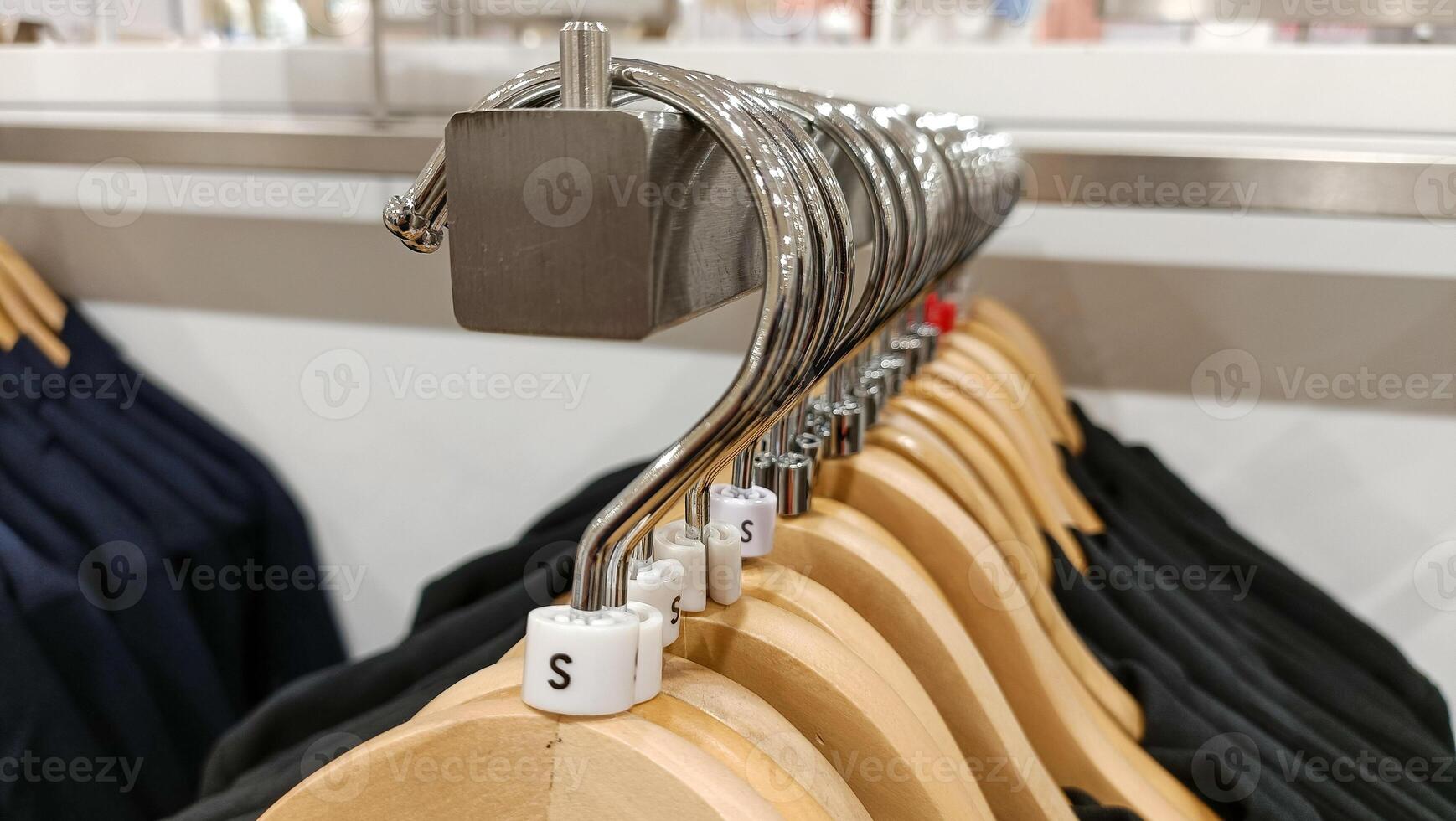 Close up view of hanging clothes arranged on a display rack small size. photo