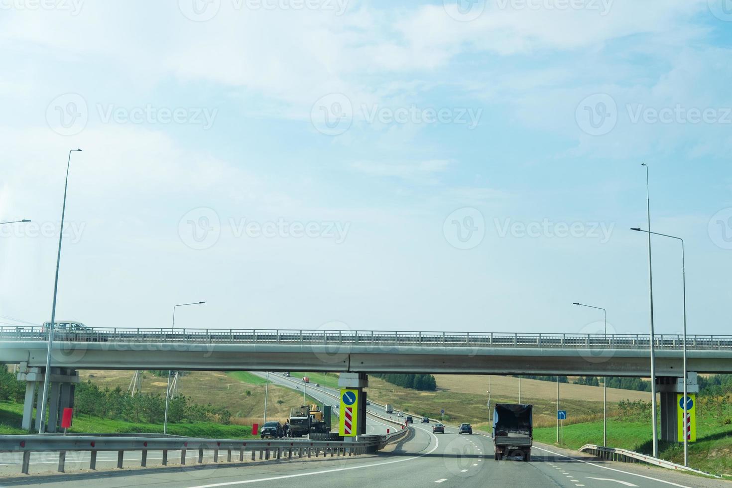 highway with a truck passing under a bridge photo