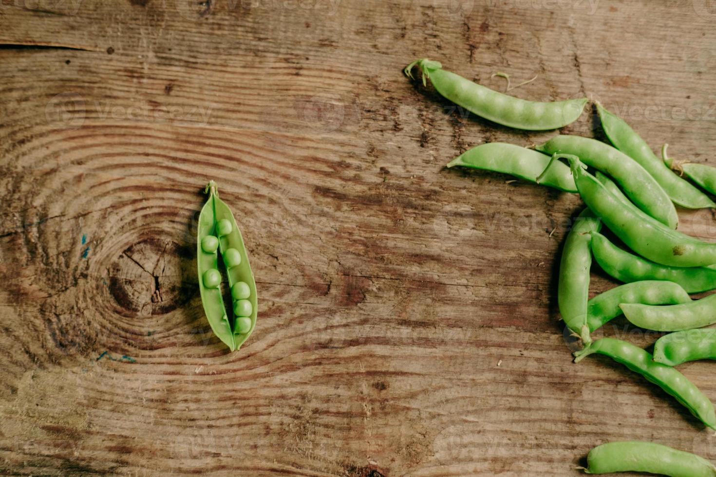 young peas on a wooden background. the view from the top. healthy snack. Vegan food. peas open photo