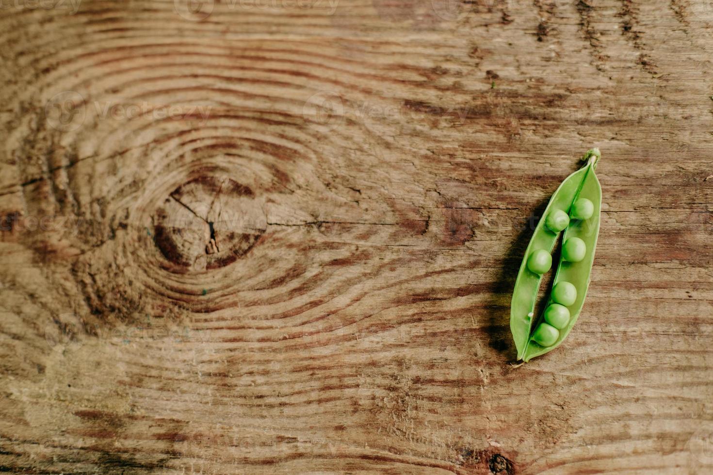 young peas on a wooden background. the view from the top. healthy snack. Vegan food. peas open photo