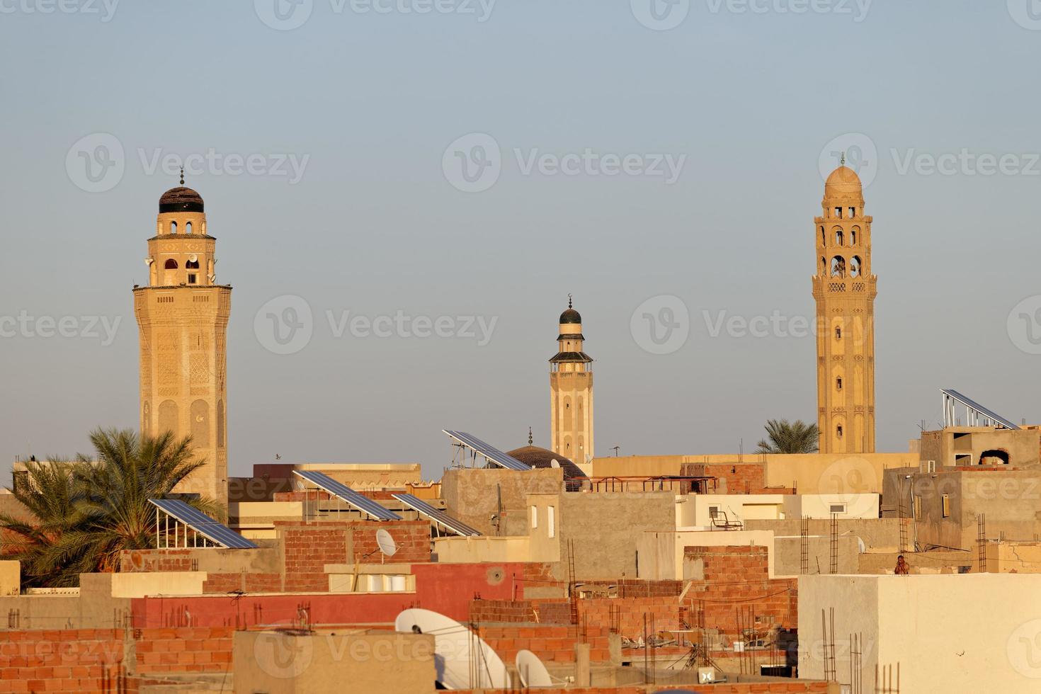 vista del paisaje urbano de la ciudad de tozeur en túnez durante la puesta de sol con minaretes de mezquita en el fondo. medina de tozeur, ciudad vieja. lugar de interés histórico. viajes y turismo en la zona del desierto. foto