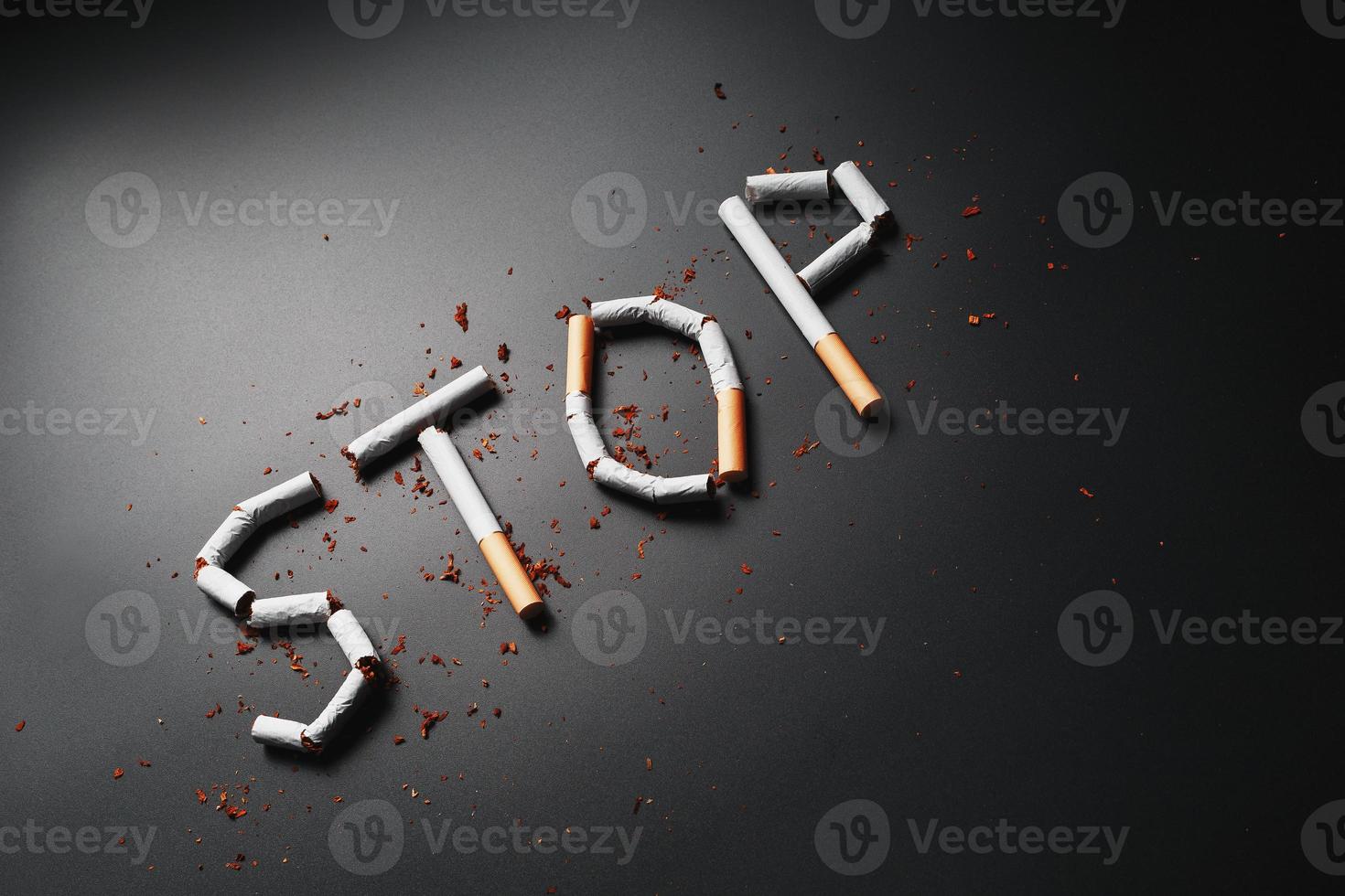 The inscription STOP from cigarettes on a black background. Stop smoking. The concept of smoking kills. Motivation inscription to quit smoking, unhealthy habit. photo