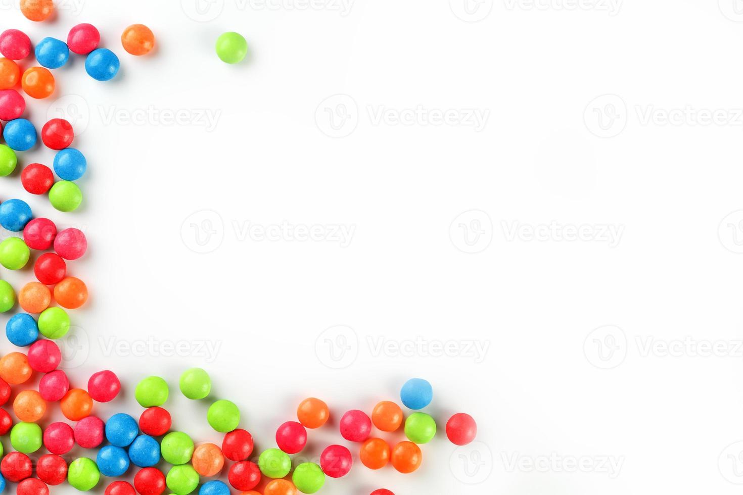 A rainbow of color from multicolored candies close-up, multi-colored glaze dragee on a white background photo