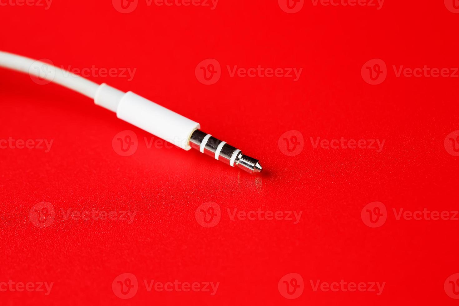 White connector AUX white cable on a red background photo