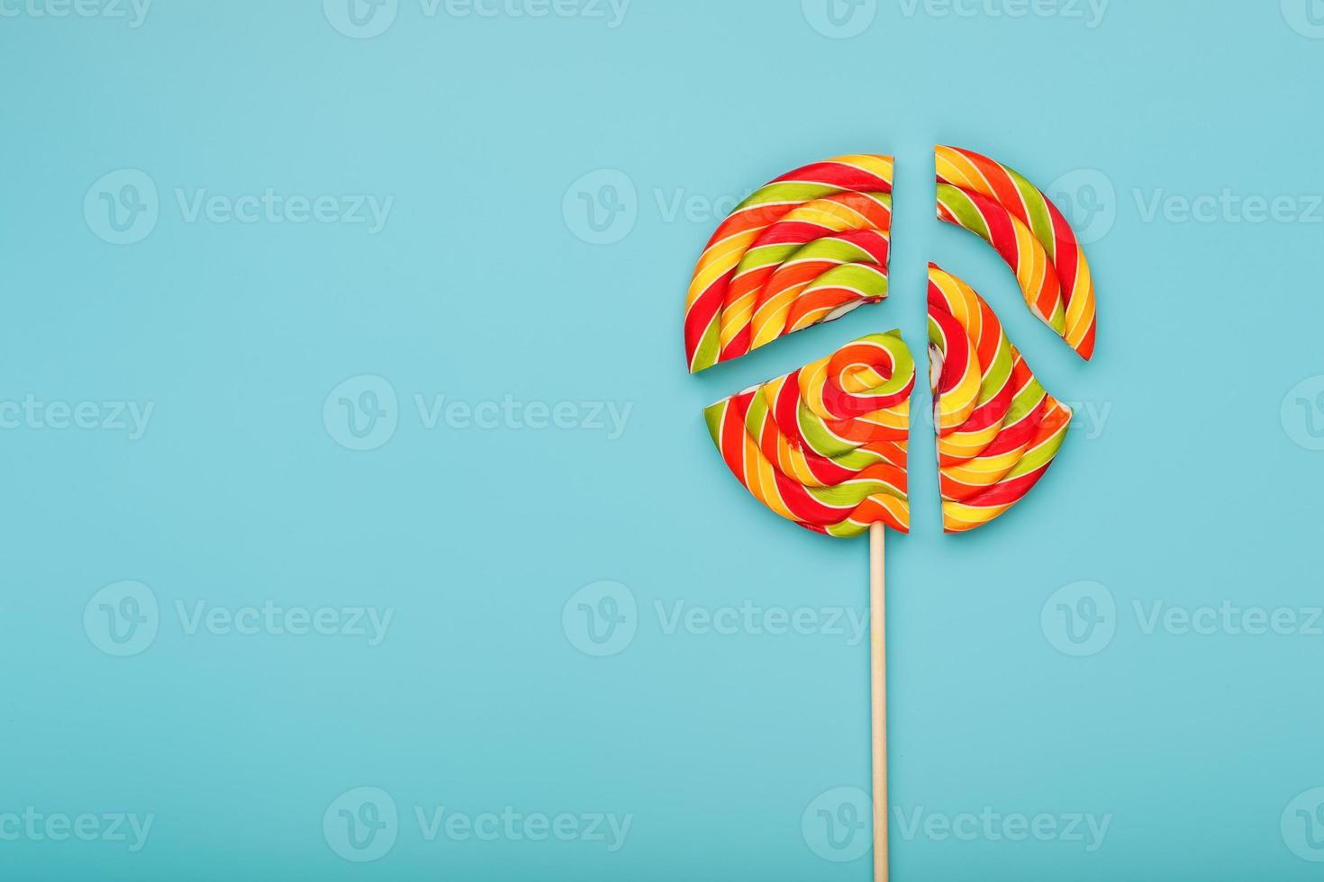 Lollipop broken into pieces on blue background, top view with copy space. photo