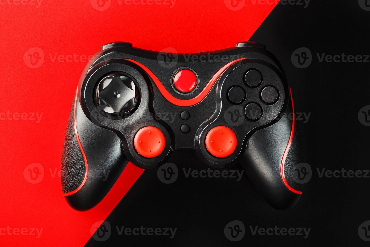 Black gamepad on a black red background, . Gaming concept. photo