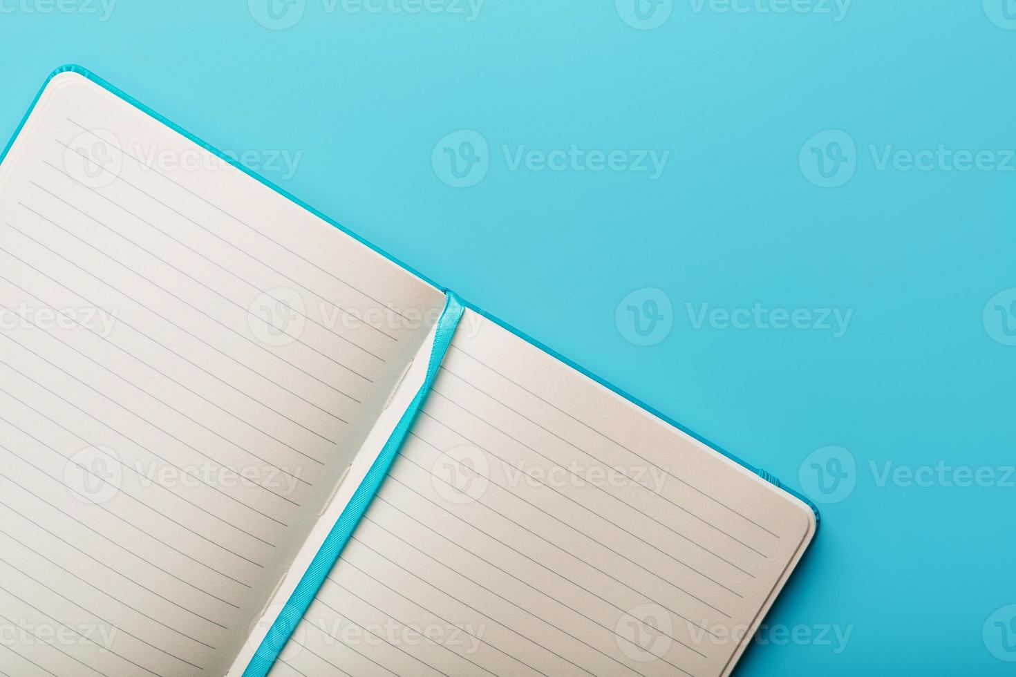 Open notebook, a book with blank and blank pages on a blue background, top view. photo