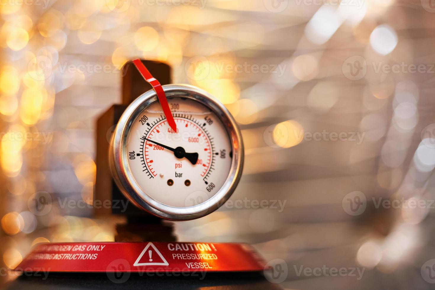 manómetro de alta presión en el sistema de aceite de equipos industriales, bombas y tuberías con una línea roja foto