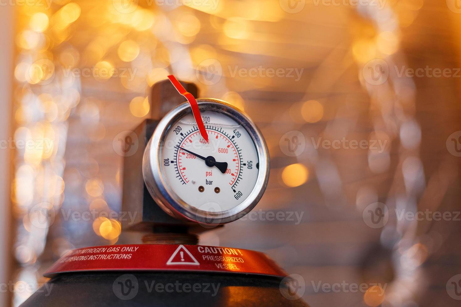 High pressure gauge in the oil system of industrial equipment, pumps and pipelines with a red line photo