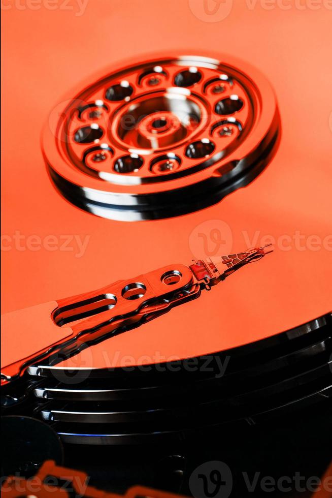 The hard disk from the computer HDD is red, with a mirror effect. The hard drive from the computer has opened. photo