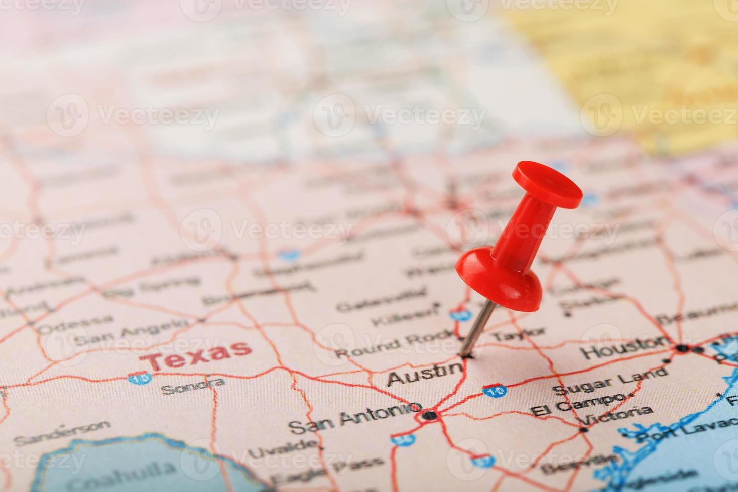 Red clerical needle on a map of USA, Texas and the capital Austin. Closeup Map Texas with Red Tack photo