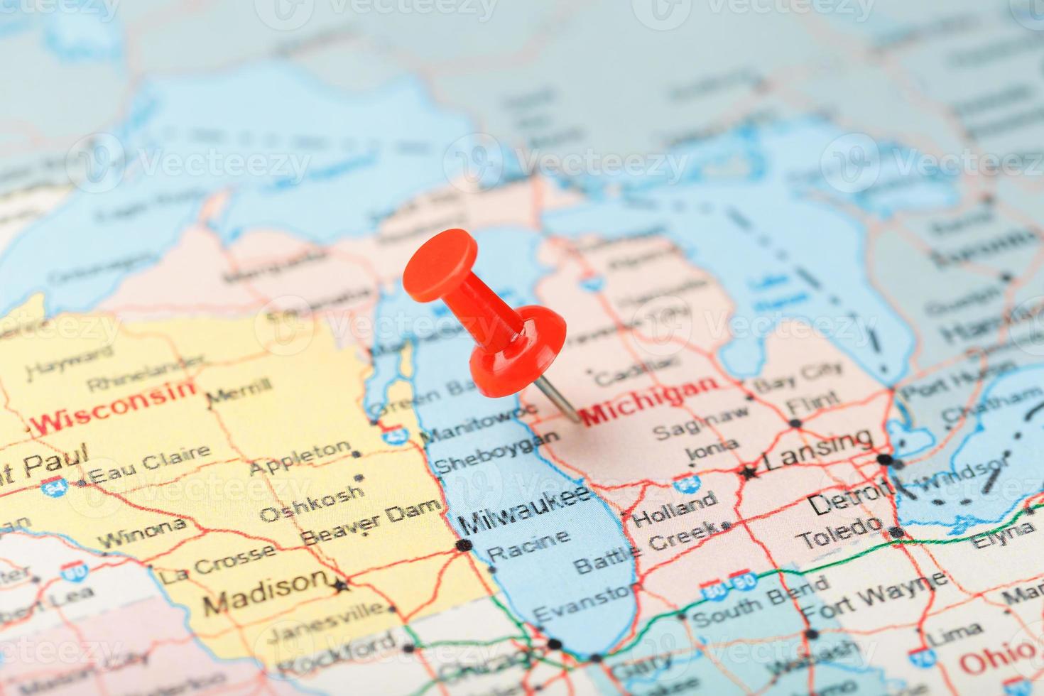 Red clerical needle on a map of USA, Michigan and the capital Lansing. Close up map of Michigan with red tack photo