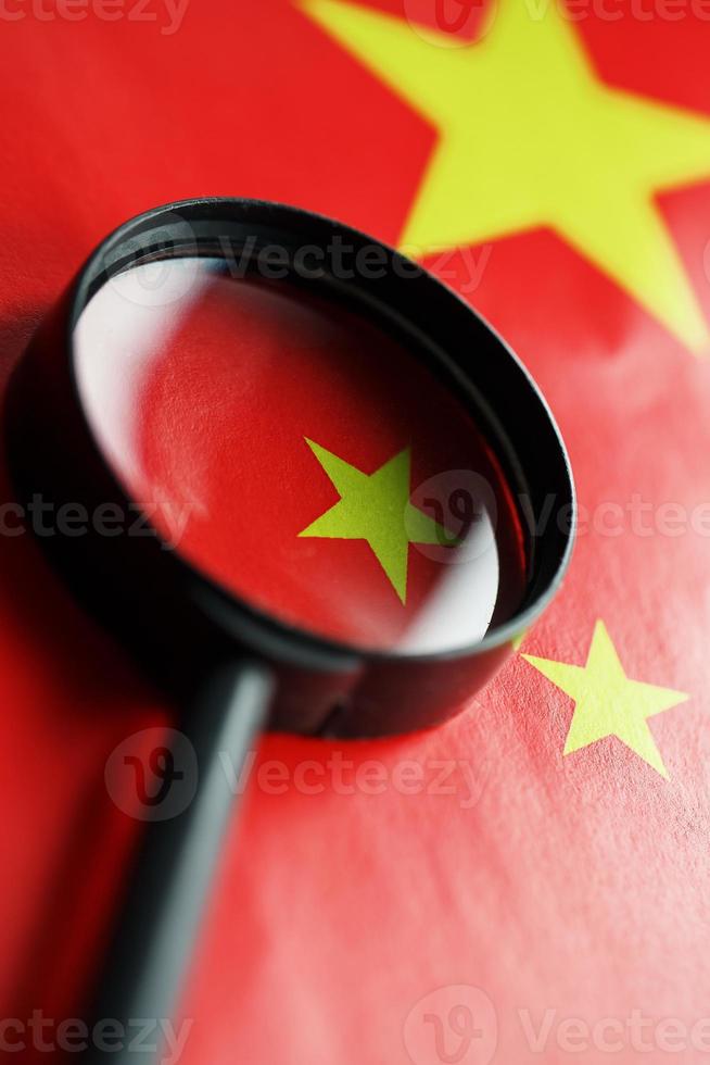 The People's Republic of China a flag is watched through magnifying glass. Spies and observation of People's Republic of China. Monitoring of a condition of China photo