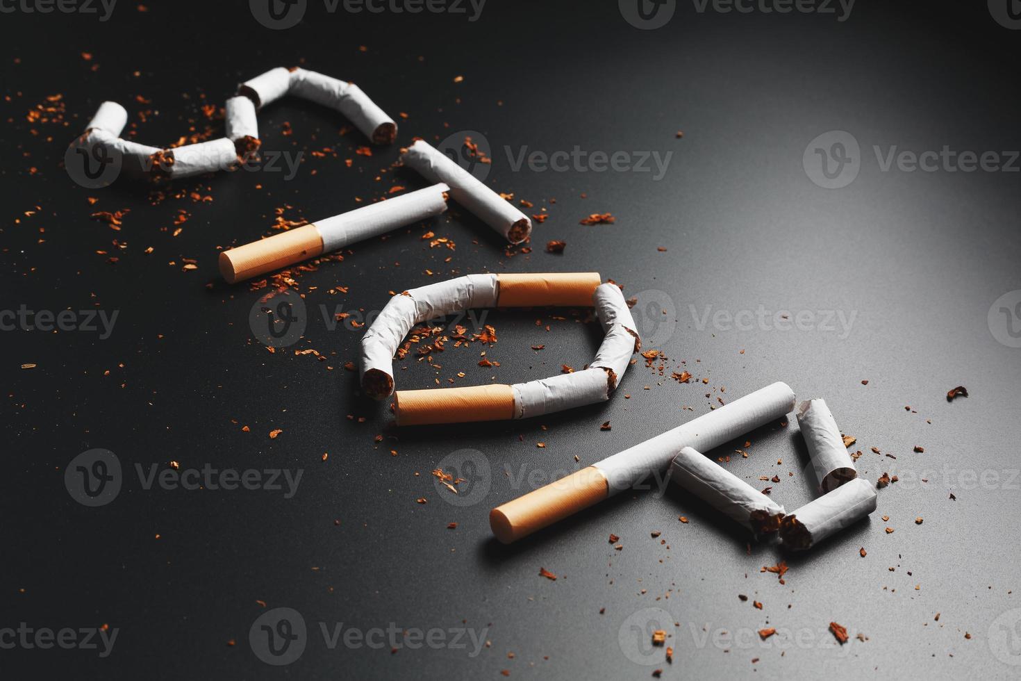 The inscription STOP from cigarettes on a black background. Stop smoking. The concept of smoking kills. Motivation inscription to quit smoking, unhealthy habit. photo