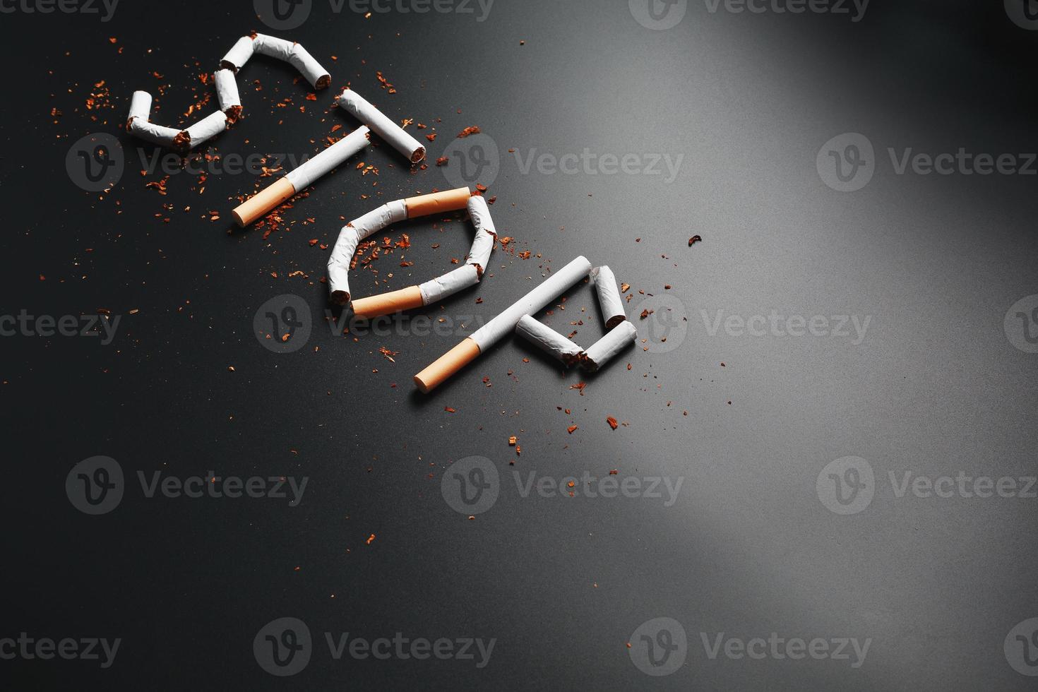 The inscription STOP from cigarettes on a black background. Stop smoking. The concept of smoking kills. Motivation inscription to quit smoking, unhealthy habit. photo