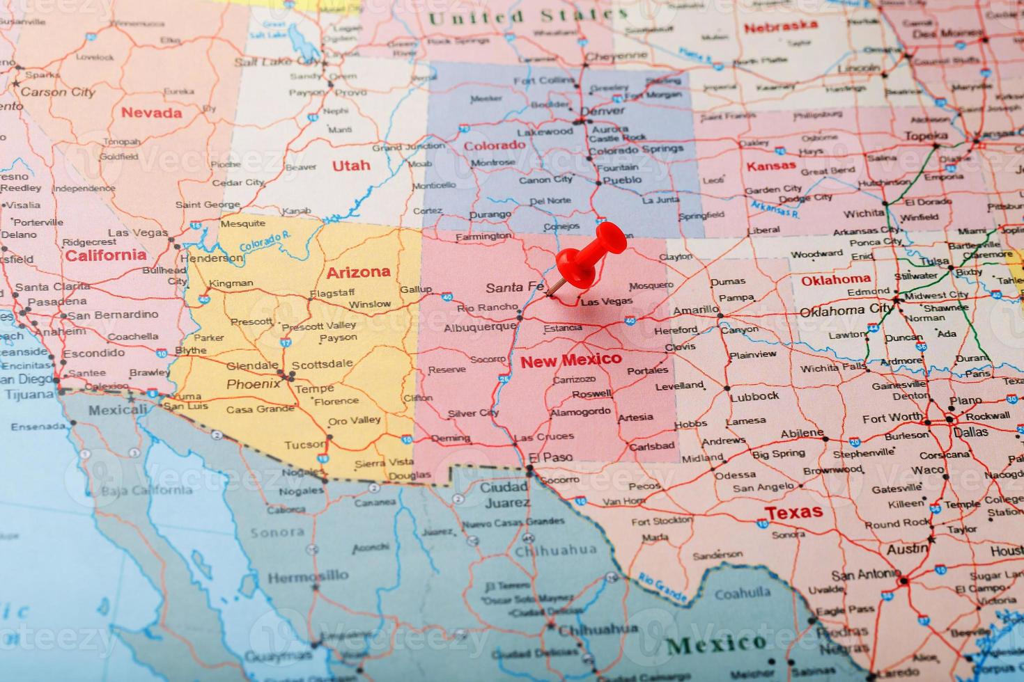 Red clerical needle on a map of USA, New Mexico and the capital of Santa Fe. Close up map of new mexico with red tack photo