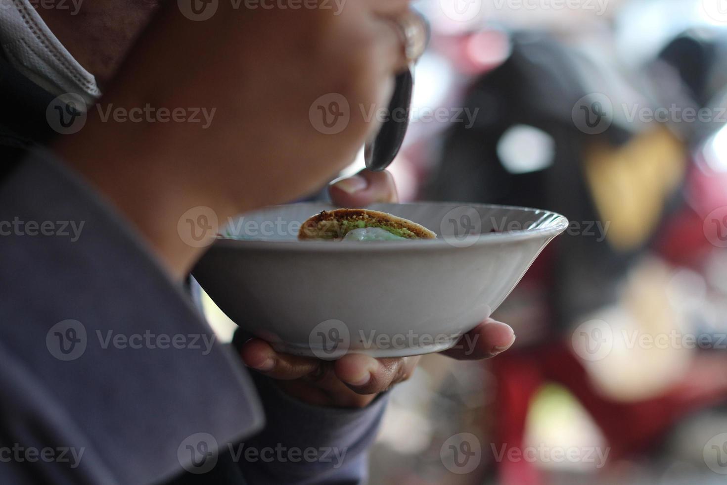traditional cake called serabi which is sweet and savory in a small bowl.is enjoying. photo