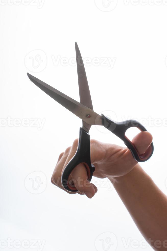 Hand holding scissors on a white backgruond photo