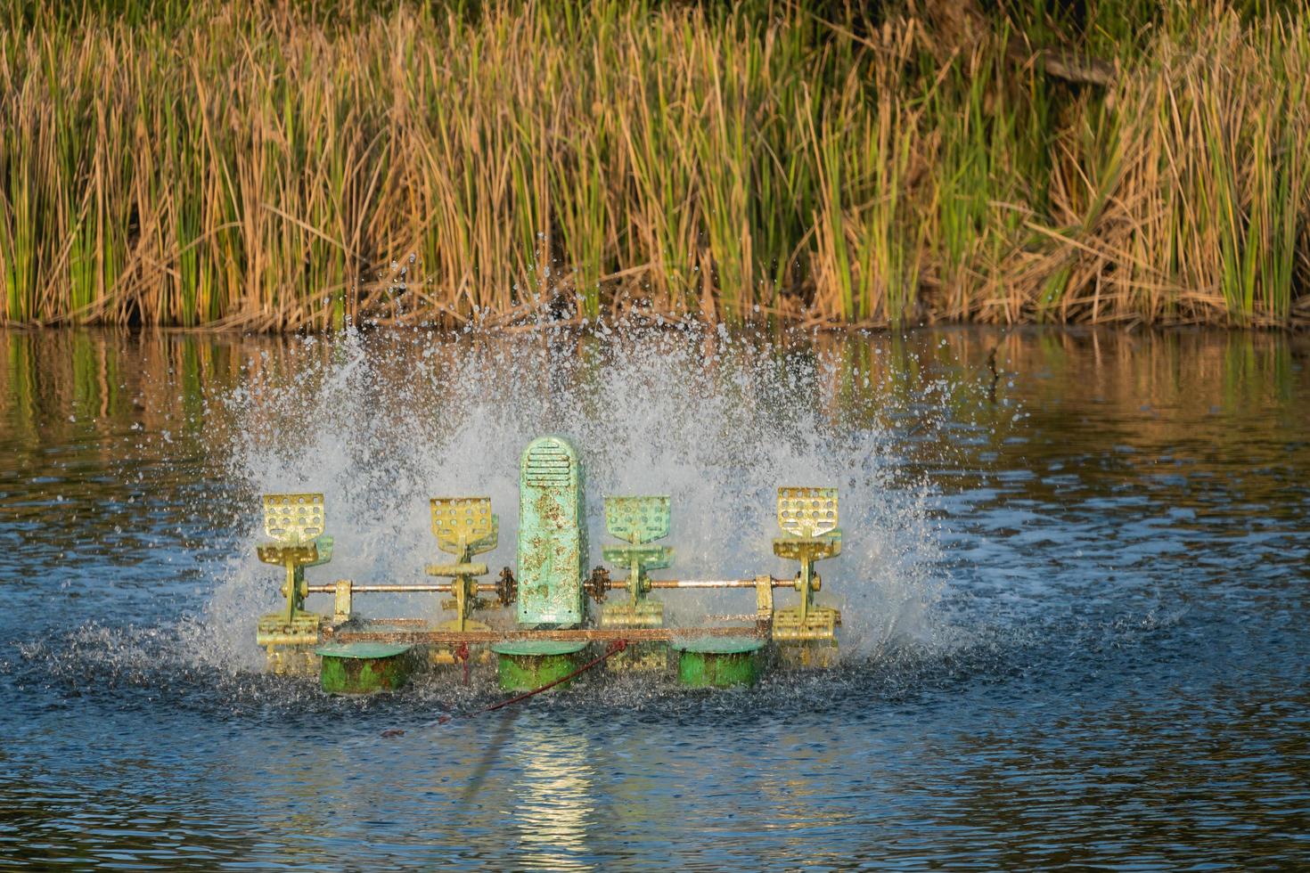 Water treatment concept. Aerator turbine wheel fill oxygen into water, high shutter speed captures multiple water splash,select focus with shallow depth of field. Wastewater treatment conservation. photo