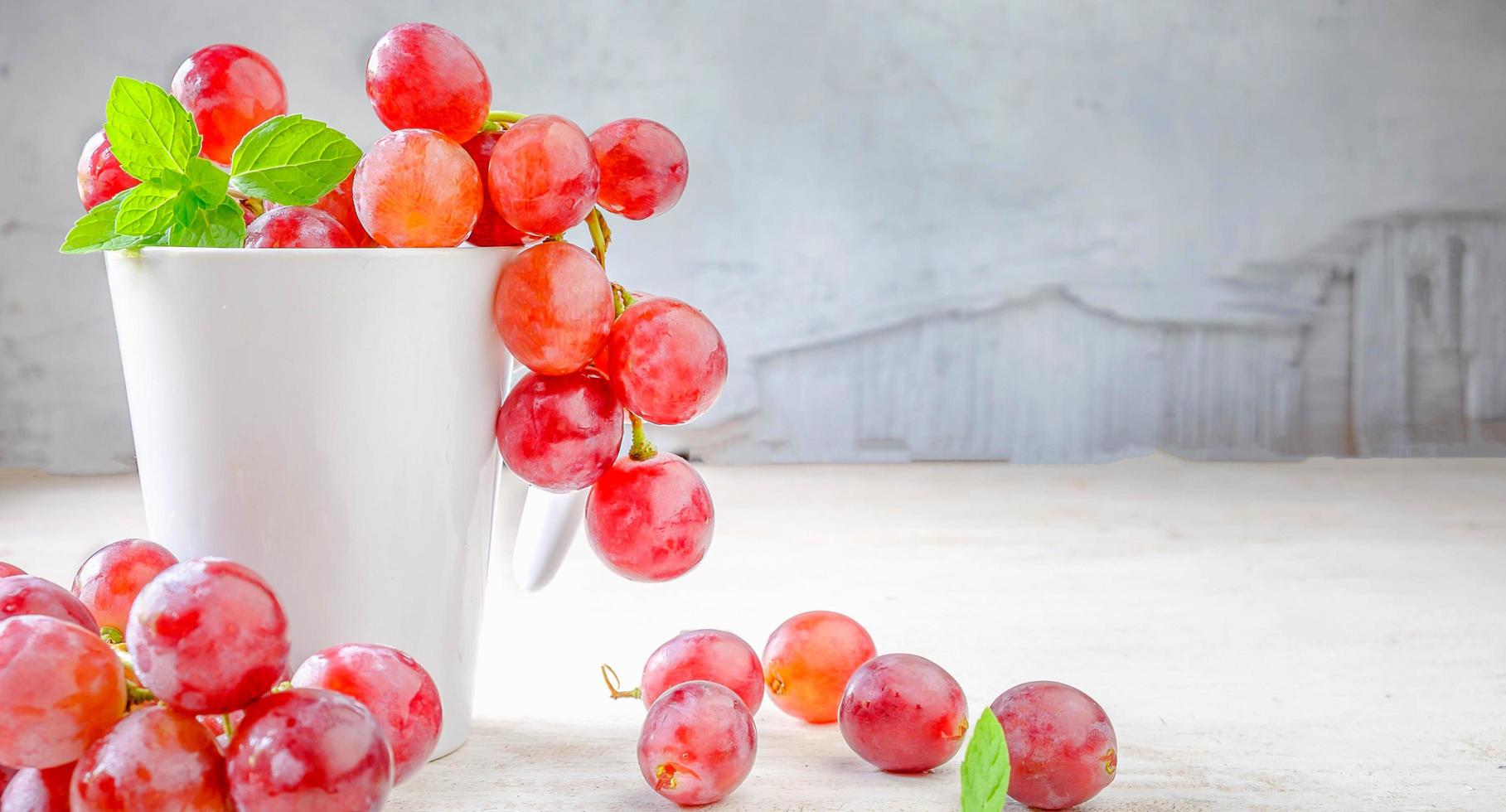 el globo rojo fresco o la variedad de uva se colocan sobre un fondo blanco de madera del viñedo foto