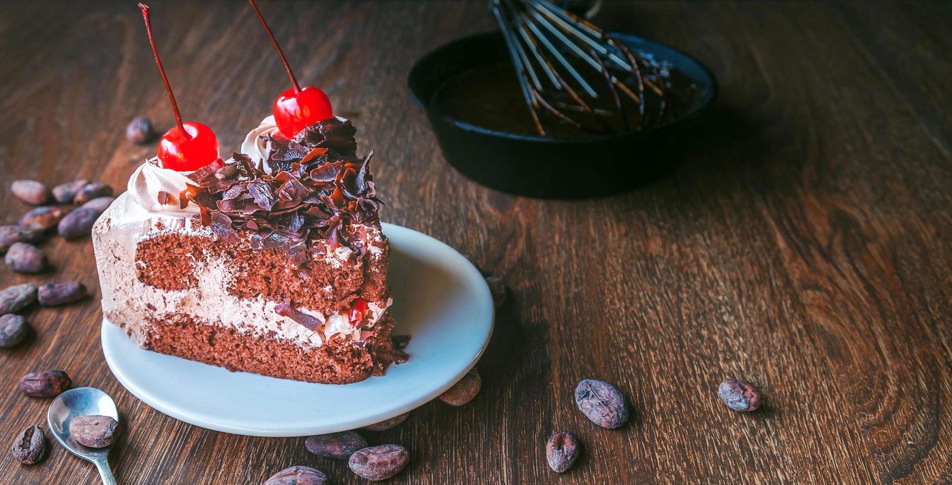 Homemade tasty chocolate cake with berries and Baker or chocolatier preparing chocolate  whisking the melted chocolate with a whisk dripping onto the pan below photo