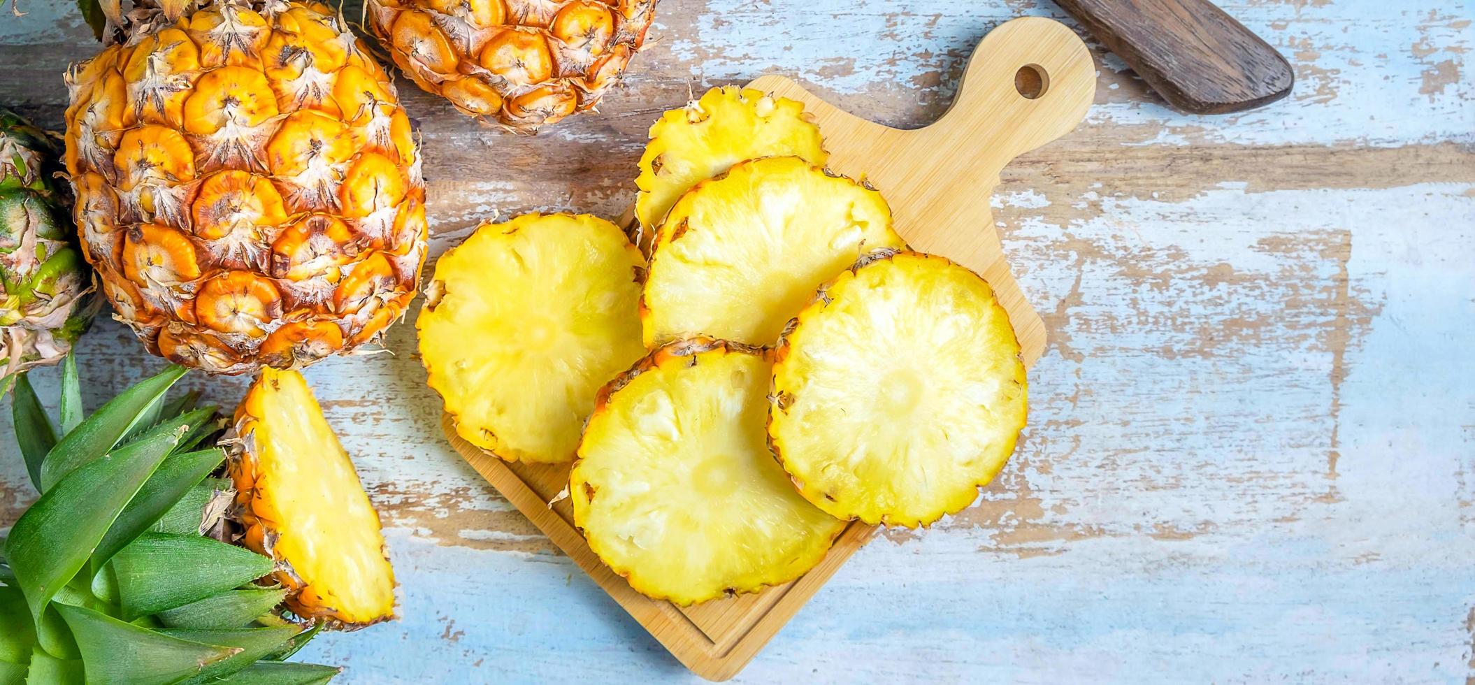 Top view of Sliced and half Pineapple and fresh pineapple fruit placed on an old wooden background photo