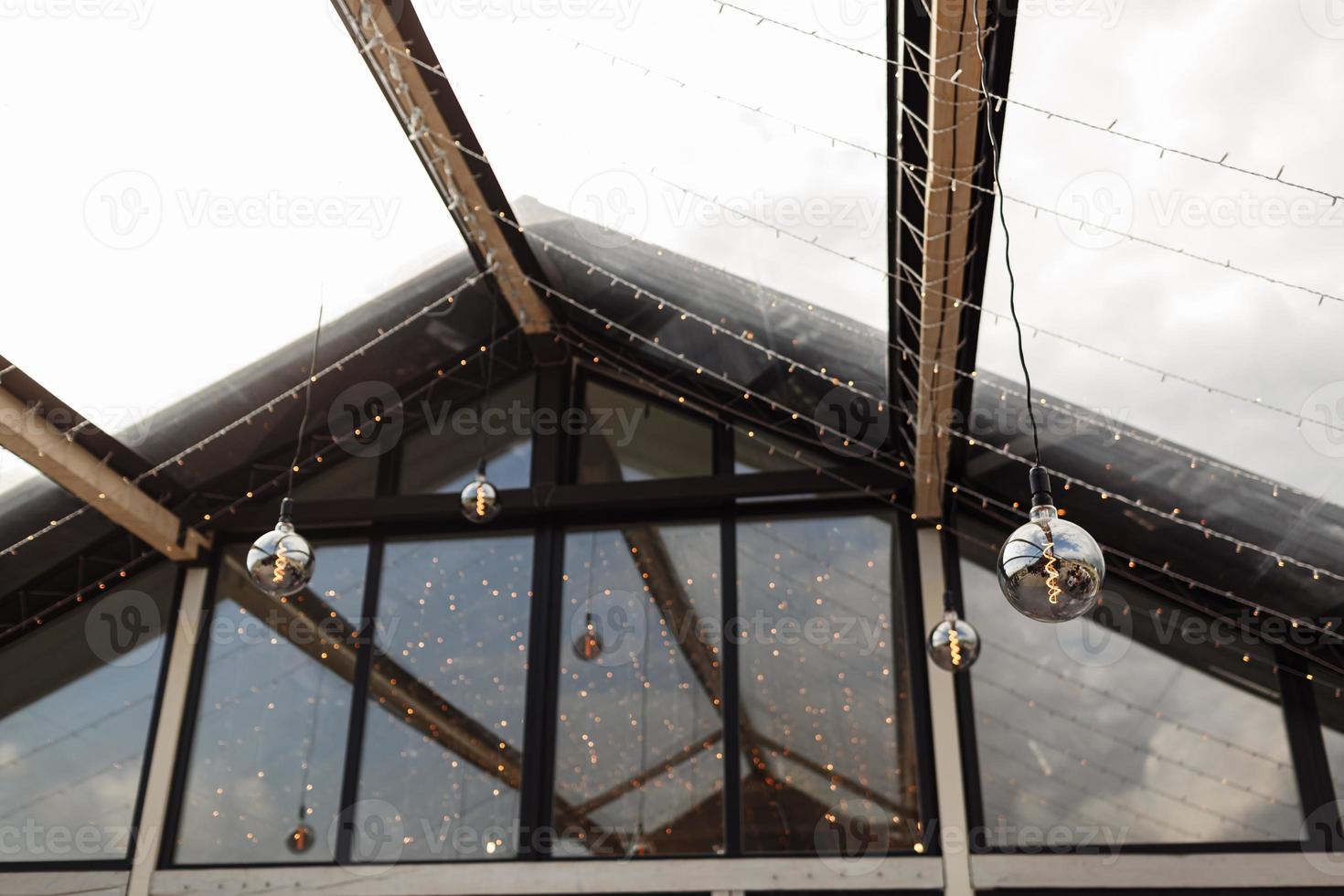 A garland of retro light bulbs on the terrace of the urban cafe. photo