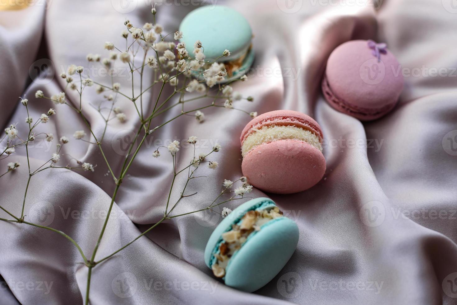 pink and mint french macaroons or macarons cookies and a white flowers on a cloth background. Natural fruit and berry flavors, creamy stuffing for valentines mother day easter with love food photo