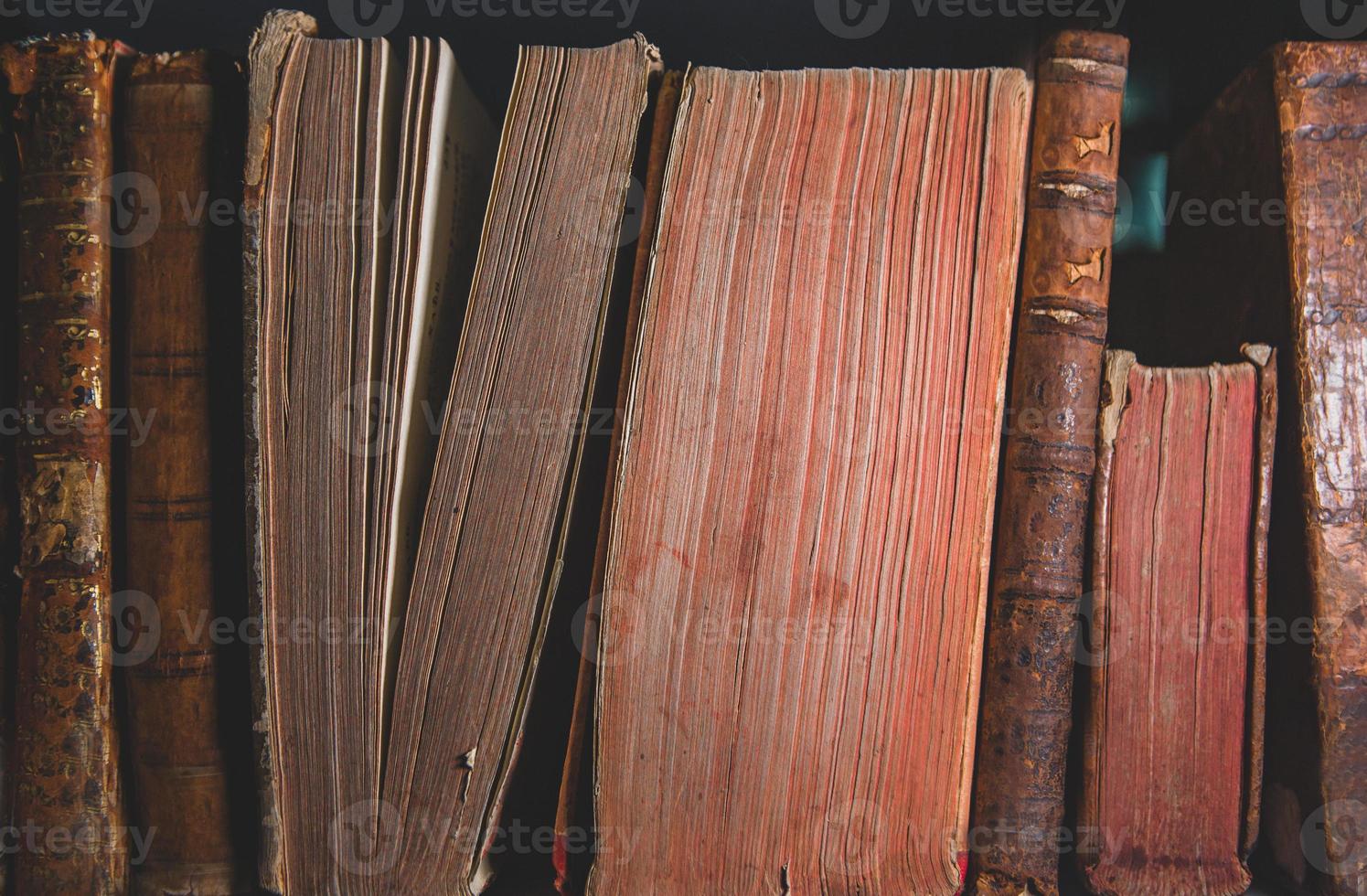 Very old books sitting on the shelves in the library. Books as a symbol of knowledge. photo