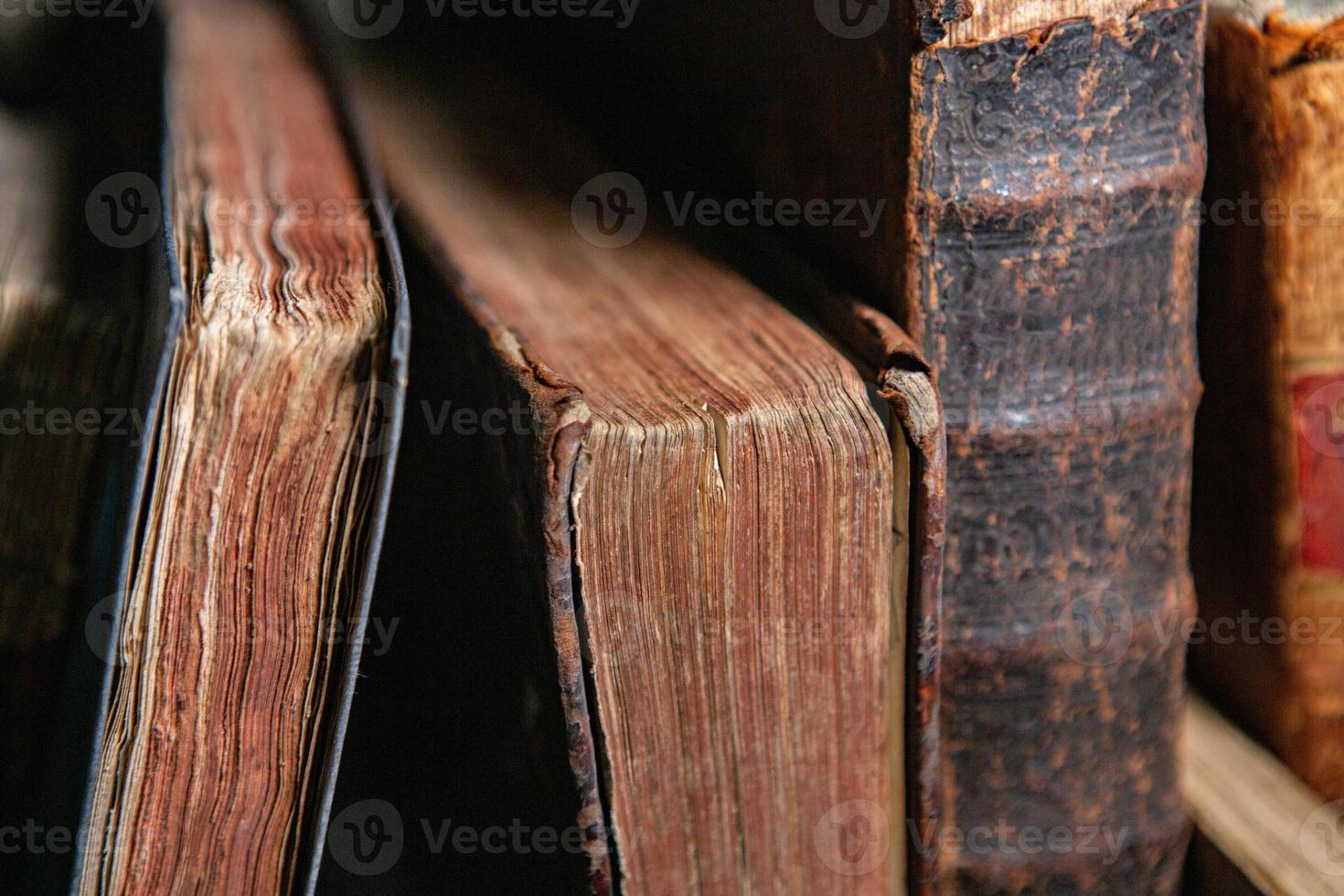 Very old books sitting on the shelves in the library. Books as a symbol of knowledge. photo