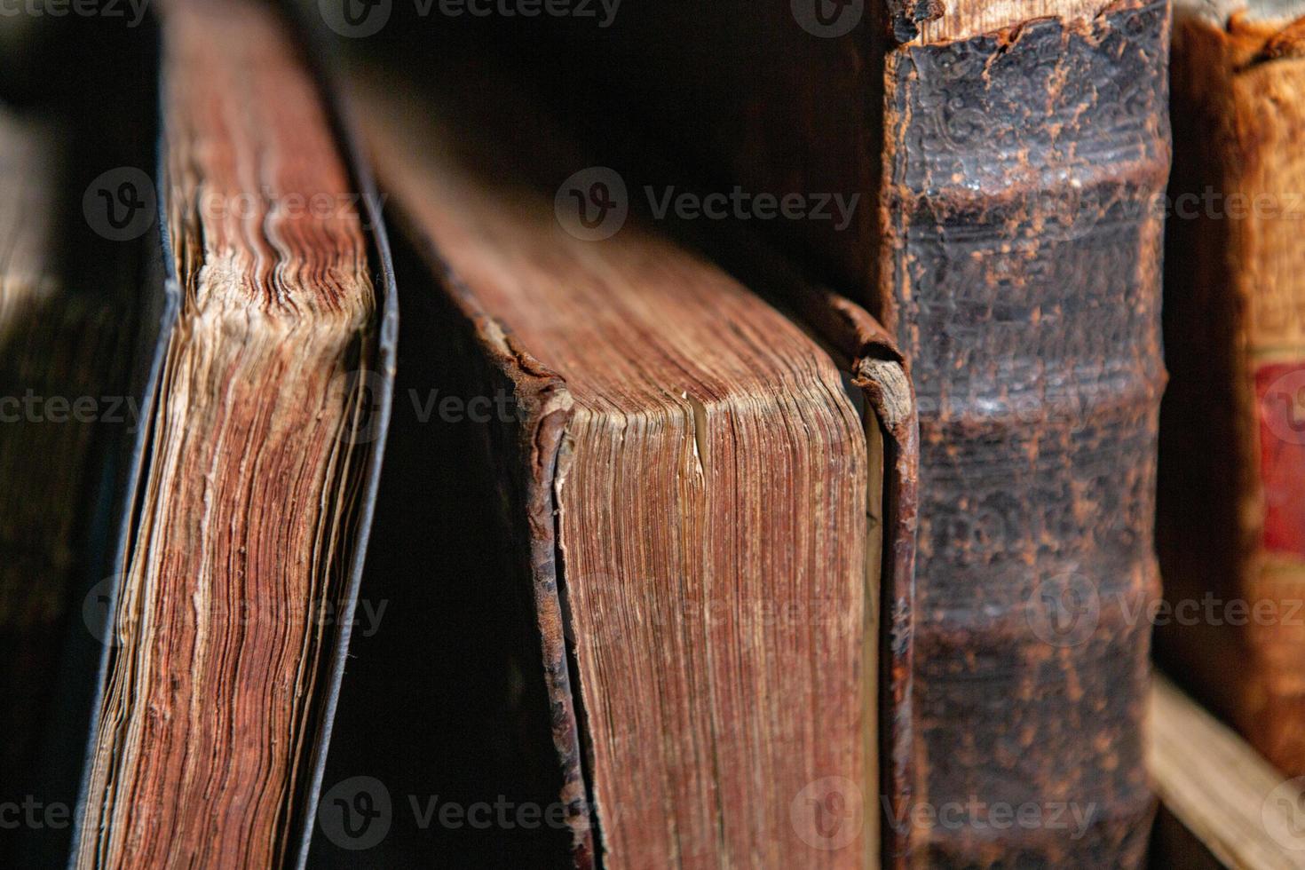 libros muy antiguos sentados en los estantes de la biblioteca. libros como símbolo del conocimiento. foto