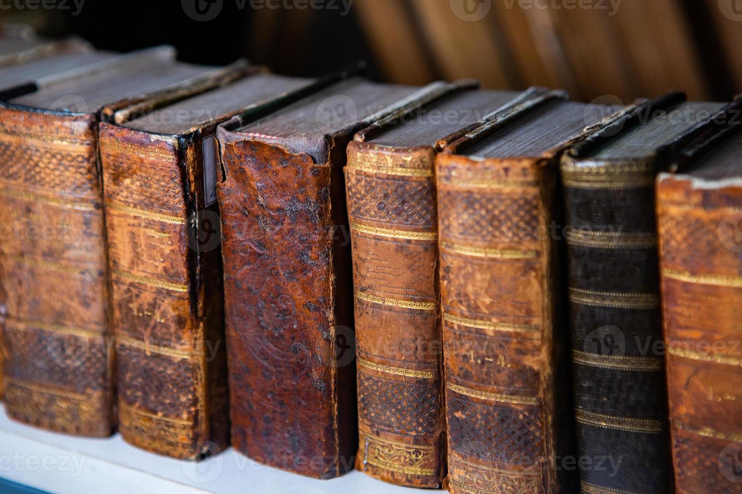 Very old books sitting on the shelves in the library. Books as a symbol of knowledge. photo